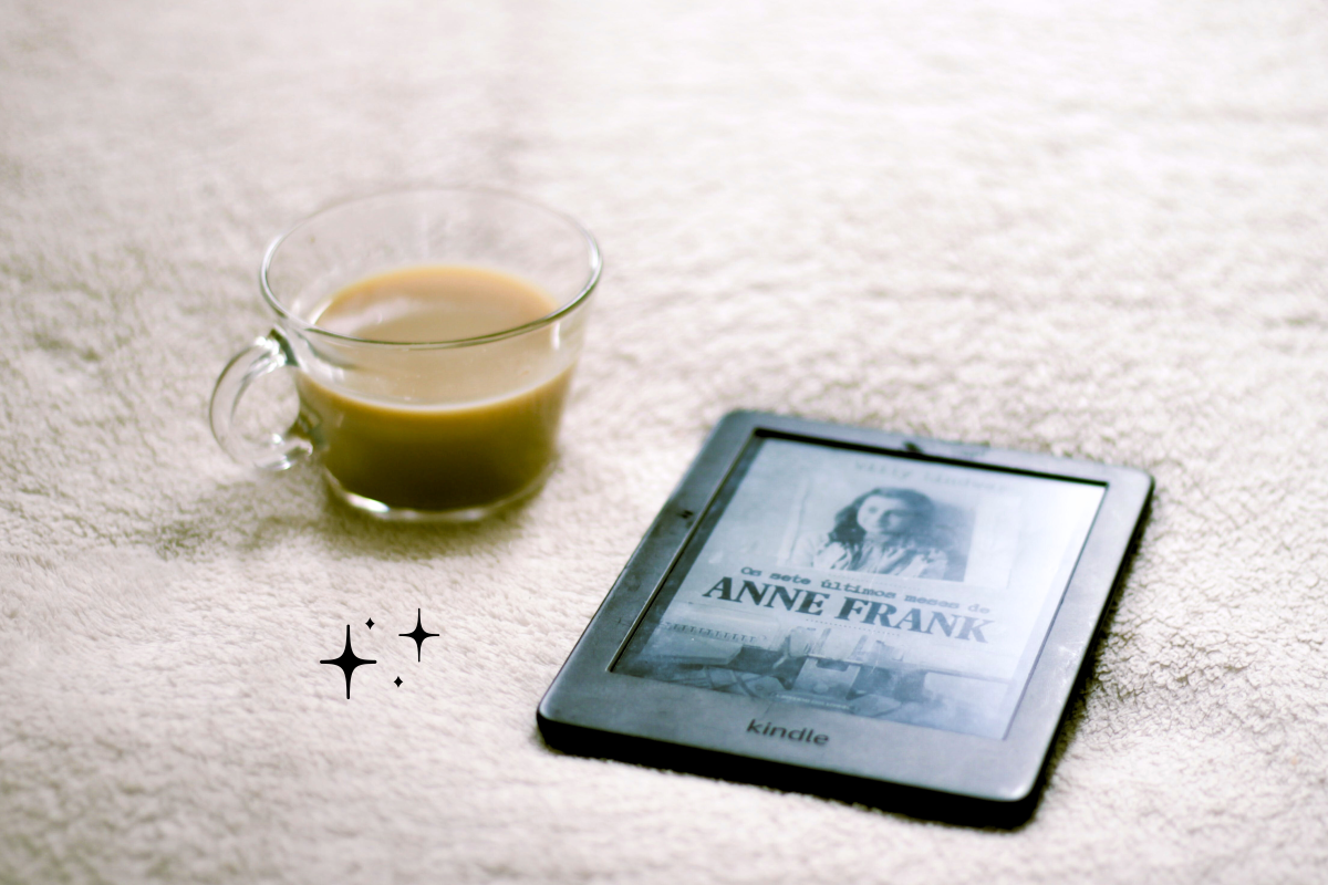 An Amazon Kindle device with a cup of coffee. the image has a warm, cozy feel.